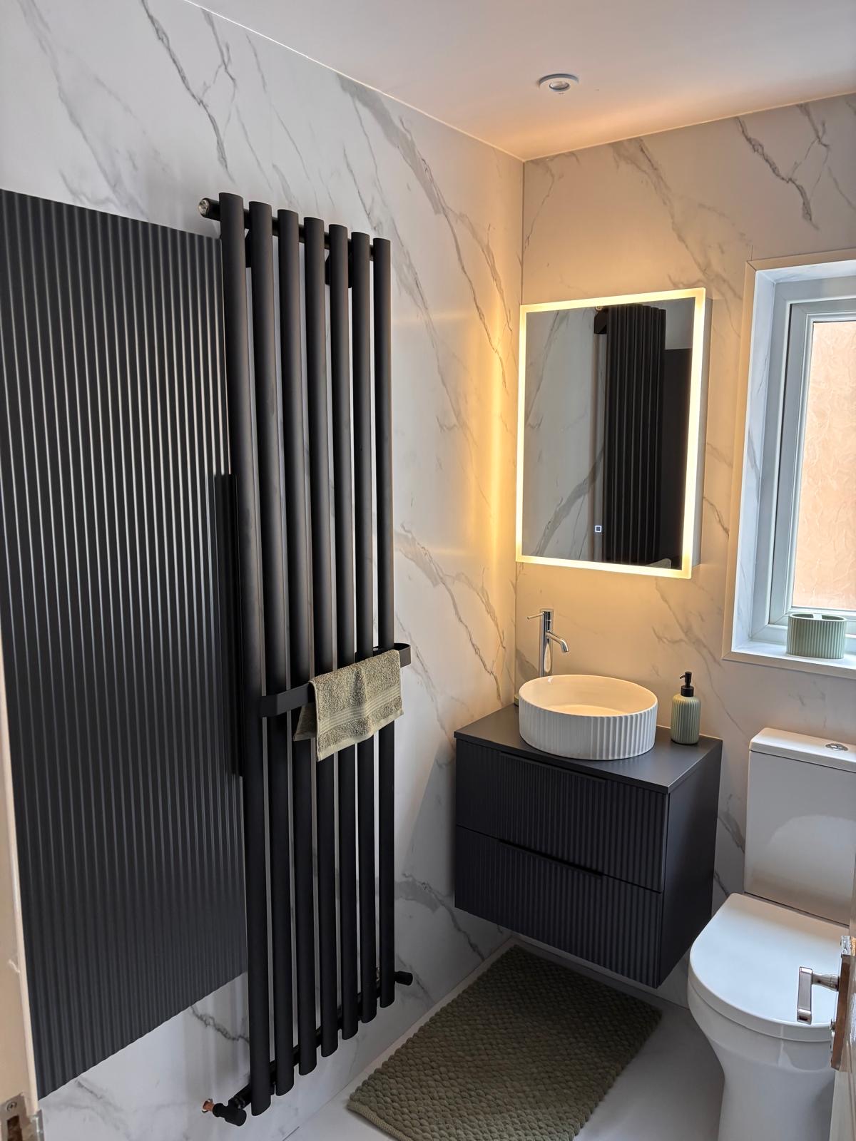Statement marble cloakroom with black fluted radiator