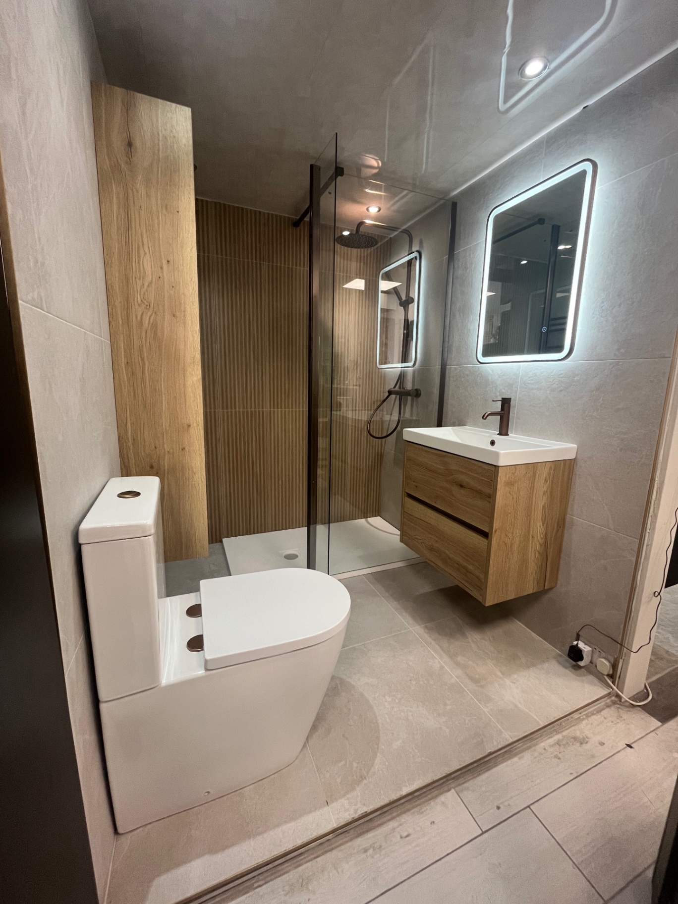 Walk-in wet room with oak vanity and fluted panel