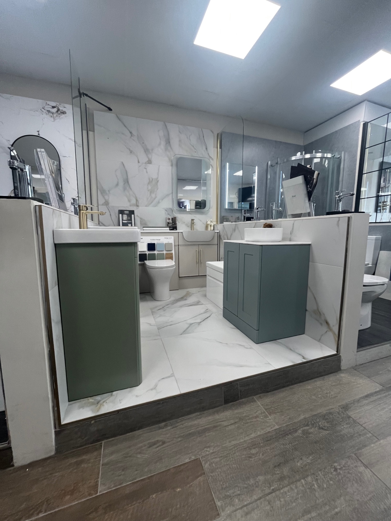 Sage and teal vanity units with marble surrounds