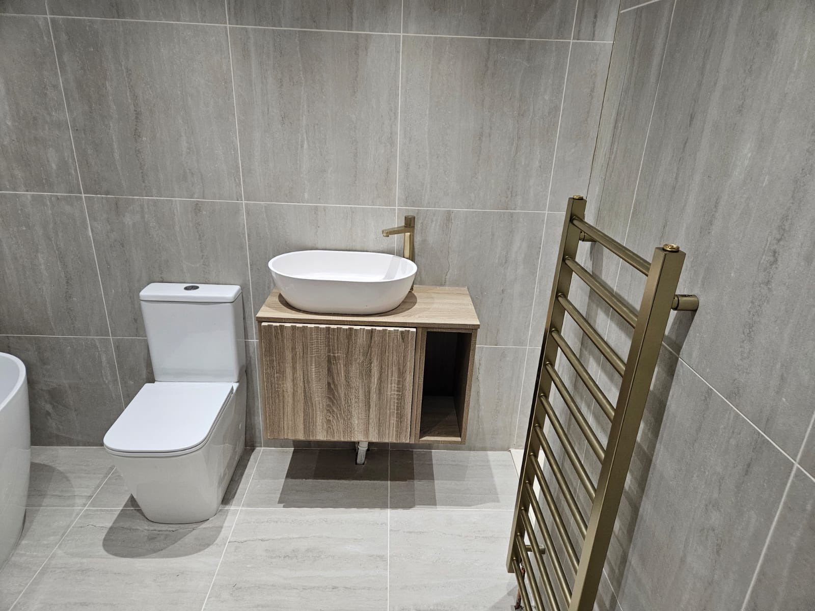 Compact suite with brushed brass rail and oak vanity